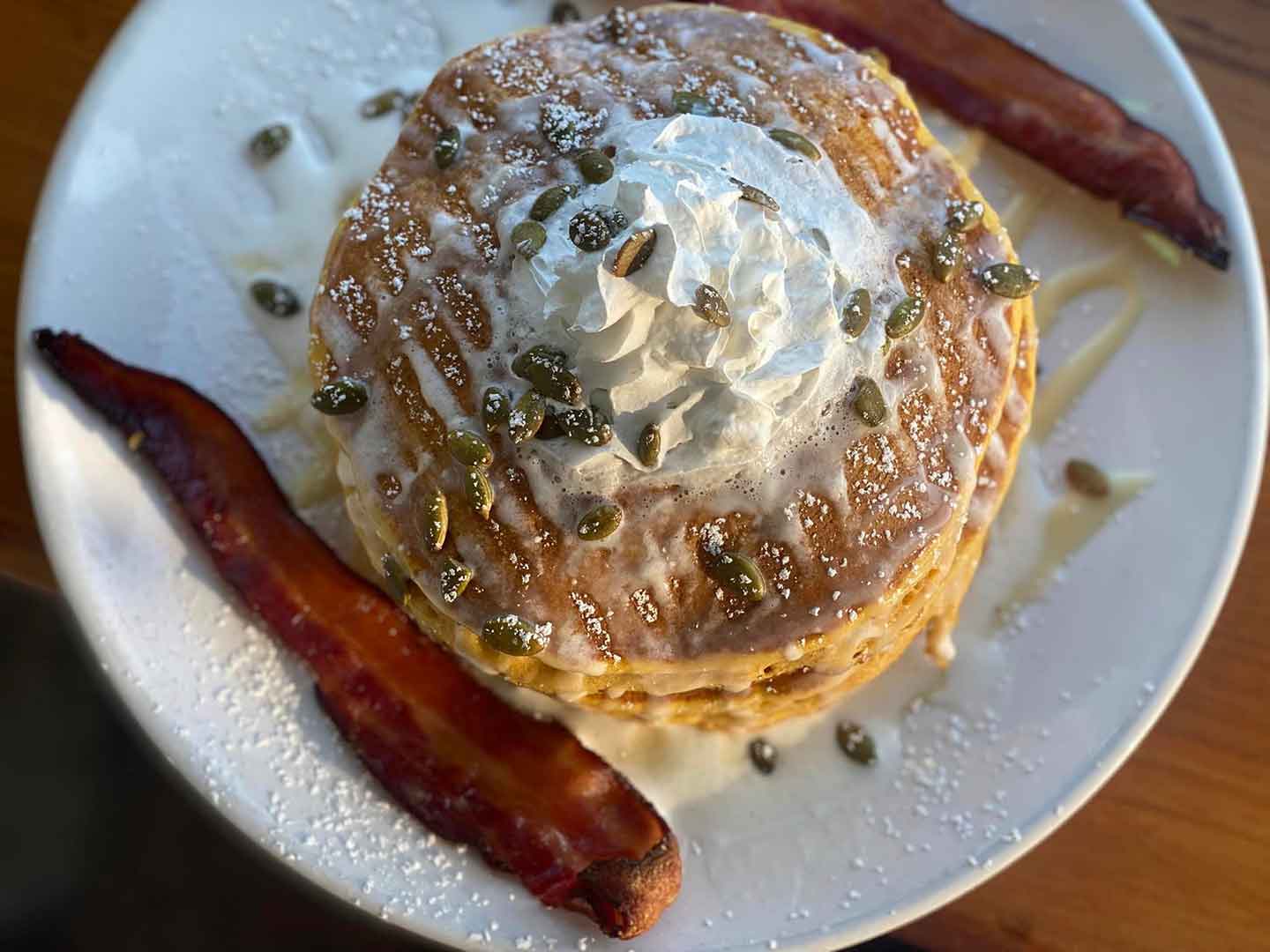 Stacked pancakes with bacon on the side at Aurora
